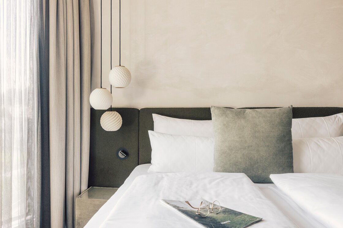 Schlafzimmer im Luxury Apartment 7 in Fiss Ein stilvoll eingerichtetes Schlafzimmer mit großem Bett, Kissen und Hängeleuchten neben schweren Vorhängen.