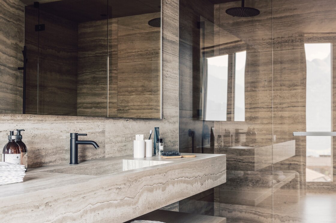 Badezimmer mit Walk-in-Dusche in Luxury Penthouse 1 Ein modernes Badezimmer mit Walk-in-Dusche, Steinoptik-Wänden und großem Spiegel.