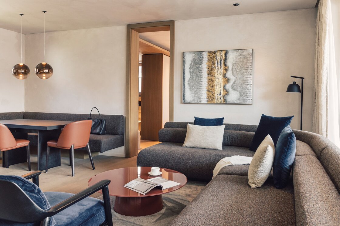 Wohnbereich im Luxury Apartment in Fiss Gemütlicher Wohnbereich mit Sofa, Esstisch und Designlampen in einem Apartment.
