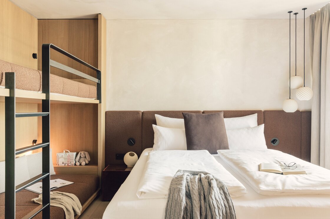 Schlafzimmer im Luxury Penthouse 1 in Fiss Ein stilvoll eingerichtetes Schlafzimmer mit Doppelbett, Etagenbett und warmen Holzelementen.