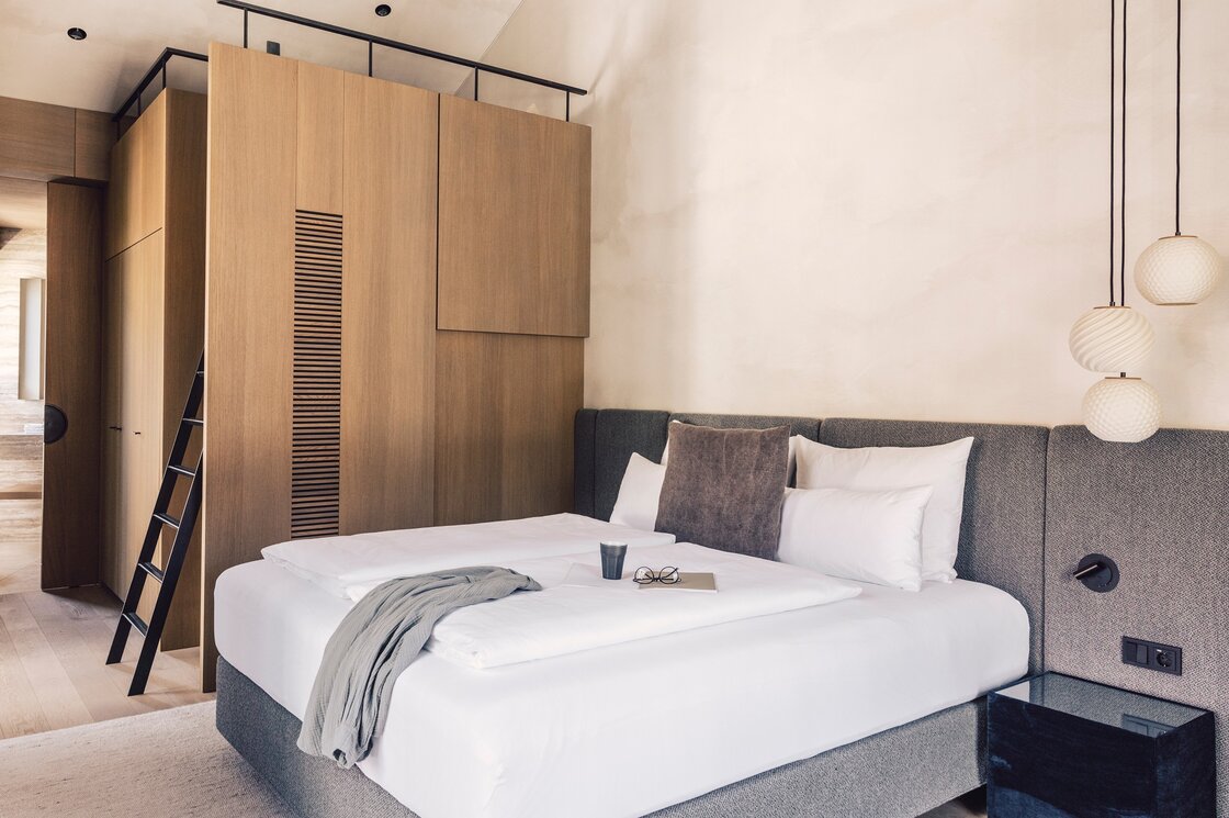 Schlafzimmer im Penthouse mit modernem Design Ein modern eingerichtetes Schlafzimmer mit Doppelbett, Holzschrank und dezenter Beleuchtung.