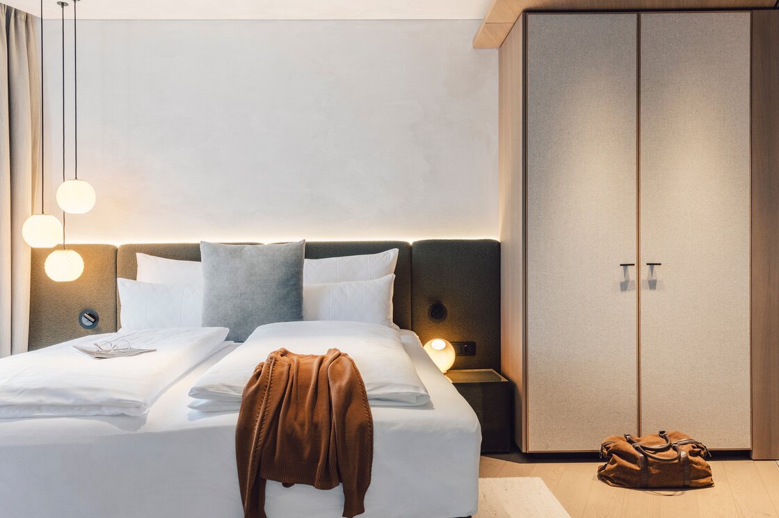 Schlafzimmer im Luxury Apartment 5 in Fiss Ein modern eingerichtetes Schlafzimmer mit Doppelbett, hängenden Lampen und großem Kleiderschrank.