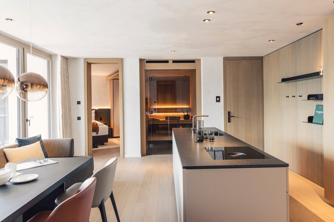 Luxury Apartment mit Küchen- und Wohnbereich in Fiss Moderner Küchen- und Wohnbereich eines Apartments mit Blick in das Schlafzimmer und den Saunabereich.