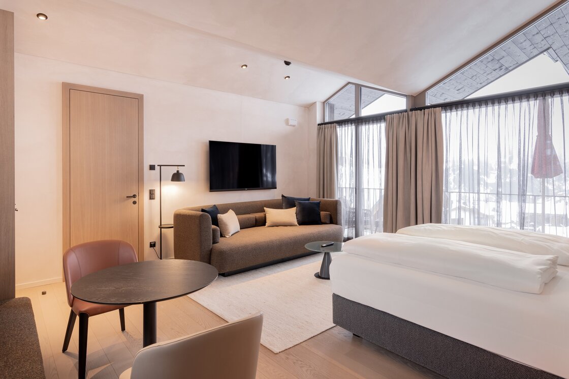 Penthouse mit Wohn- und Schlafbereich in Fiss Der kombinierte Wohn- und Schlafbereich eines Penthouse mit Sofa, Bett und großen Fenstern.