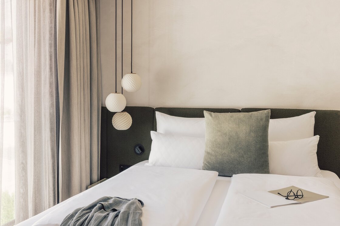 Luxuriöses Schlafzimmer im Apartment in Fiss Ein stilvoll eingerichtetes Schlafzimmer mit Doppelbett, Vorhängen und Hängelampen.