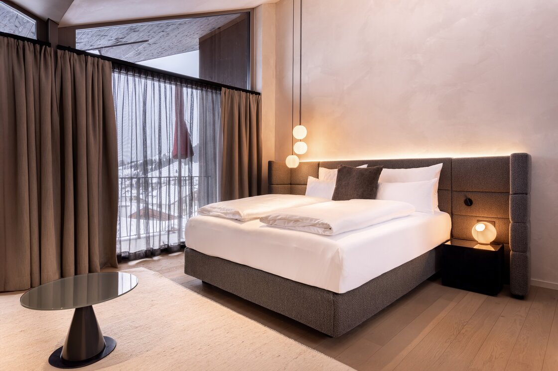 Penthouse-Schlafzimmer mit Bergblick in Fiss Ein modernes Schlafzimmer im Penthouse mit großem Bett und Blick auf die verschneiten Berge.