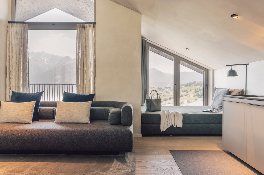 Penthouse mit Bergblick in Fiss Gemütliche Sitzecke und Schlafbereich mit großen Fenstern und Blick auf die Berge.