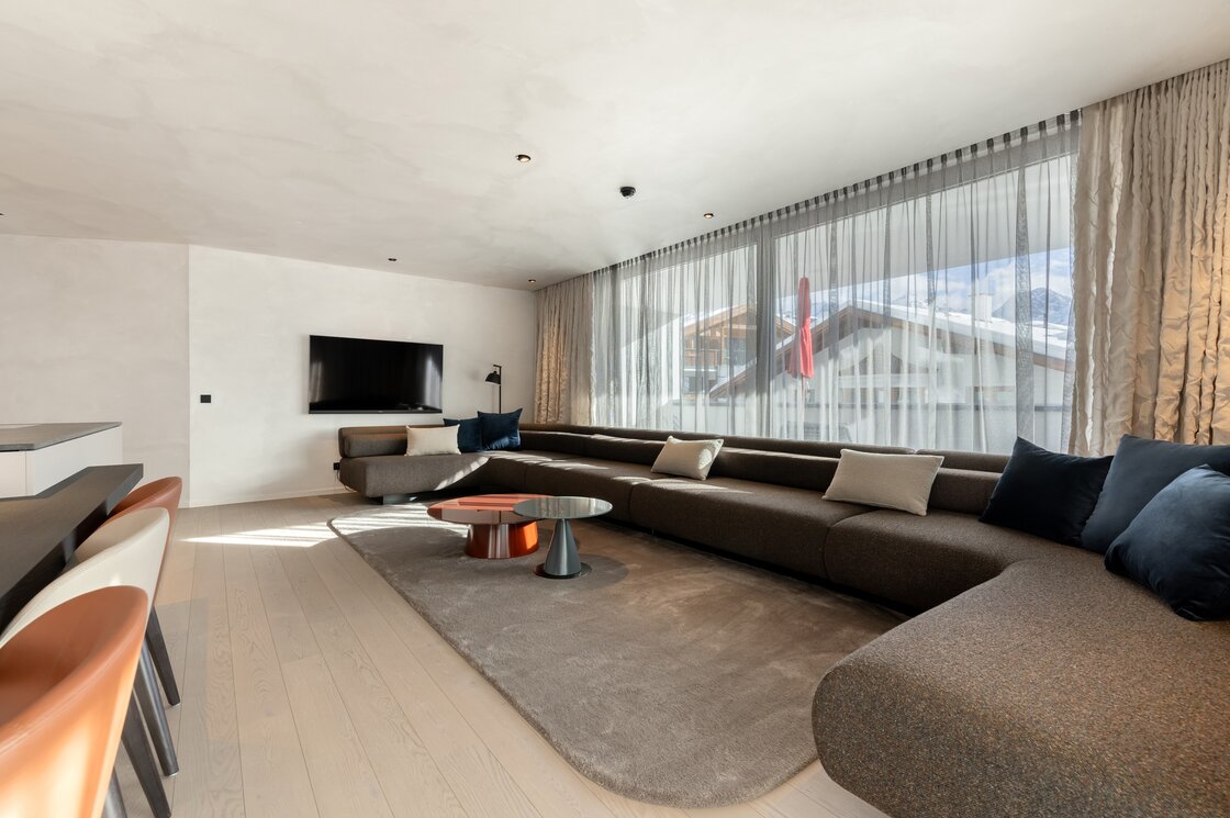 Luxuriöses Apartment mit Wohnbereich in Fiss Ein großzügiger Wohnbereich in einem modernen Apartment mit großer Fensterfront und weitem Blick nach draußen.