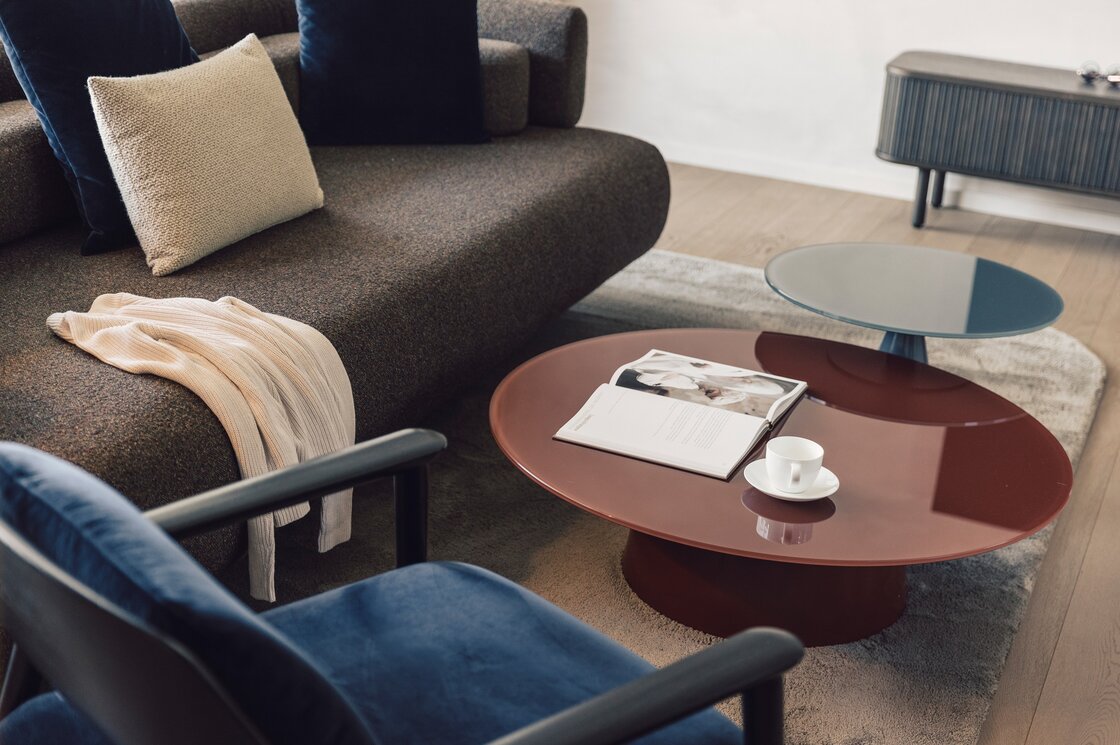 Wohnbereich im Luxury Apartment 7 in Fiss Ein moderner Wohnbereich mit Sofa, Couchtischen, Buch und Tasse in einem Apartment.