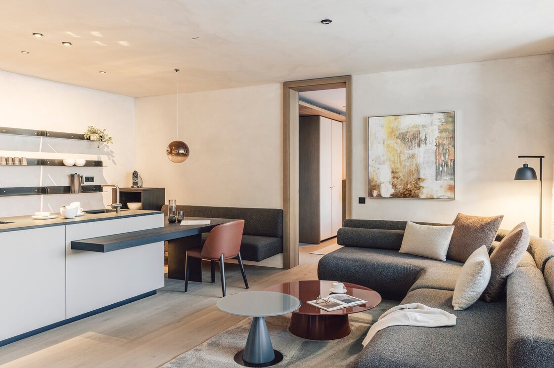 Wohn- und Küchenbereich im Luxury Apartment 1 in Fiss Wohn- und Küchenbereich eines modernen Apartments mit Sofa, Esstisch und offener Küche.