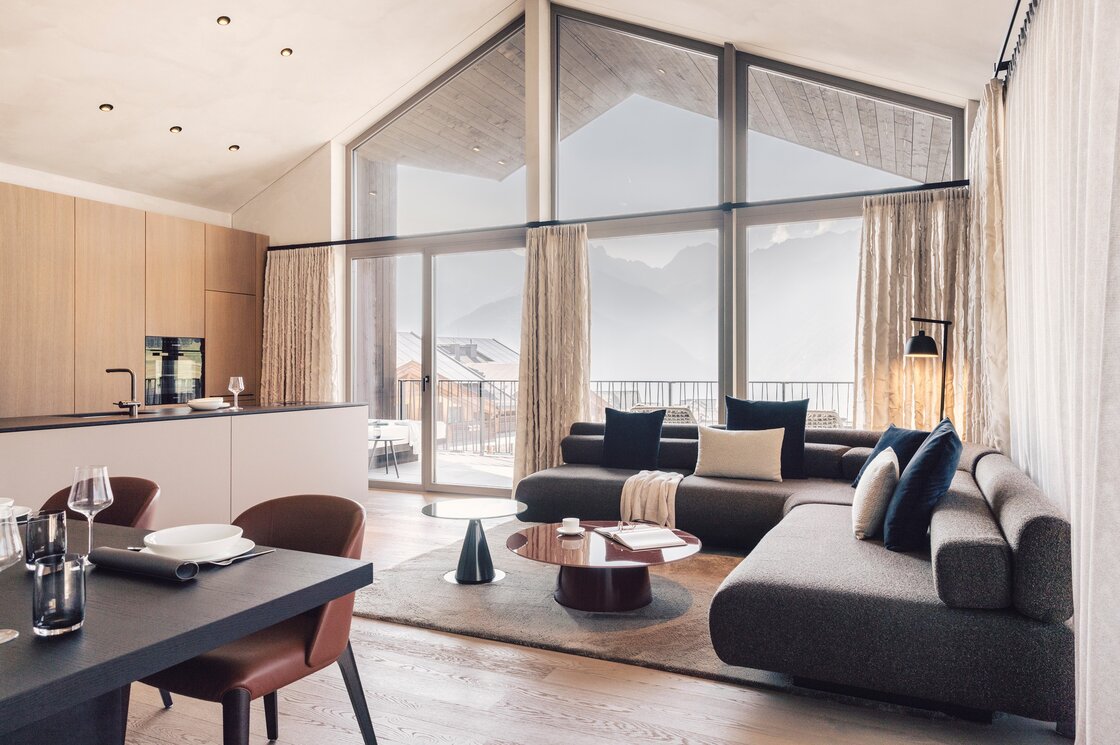 Penthouse-Wohnbereich mit Bergblick in Fiss Der offene Wohnbereich des Penthouse zeigt große Fenster, eine Küche und Blick auf die Berge.