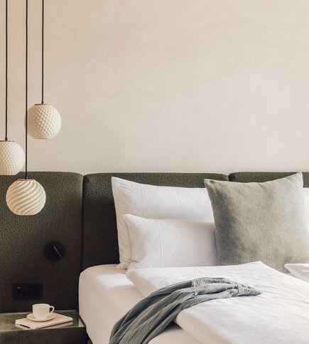Schlafzimmer im Luxury Apartment 1 in Fiss Ein stilvoll eingerichtetes Schlafzimmer mit Doppelbett, gepolstertem Kopfteil und hängenden Leuchten.