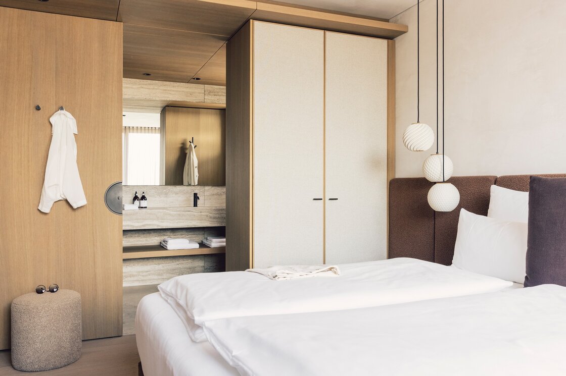 Schlafzimmer im Luxury Apartment 3 in Fiss Ein modernes Schlafzimmer mit Doppelbett, Einbauschrank und offenem Badbereich.